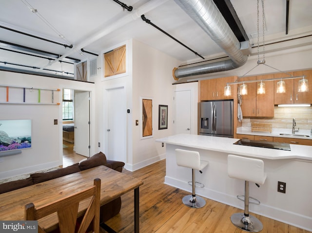 200 Lincoln Ave Unit 213, Phoenixville, PA 19460 - kitchen featuring stainless steel refrigerator with ice dispenser, a sink, light countertops, a breakfast bar, and light wood-style floors