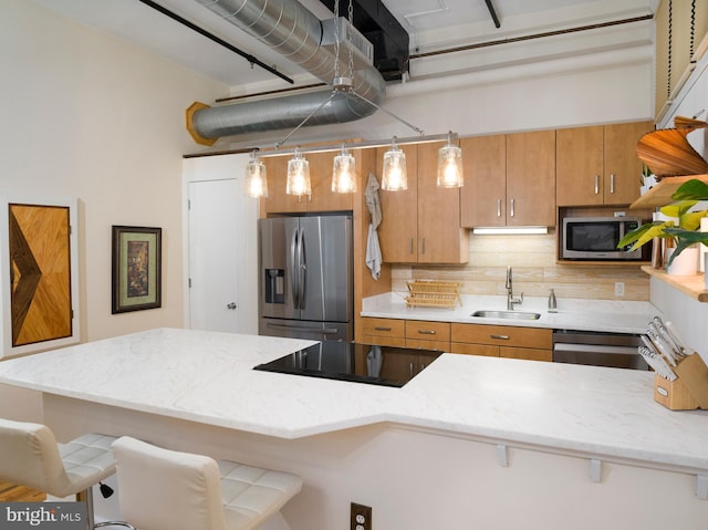 200 Lincoln Ave Unit 213, Phoenixville, PA 19460 - kitchen featuring appliances with stainless steel finishes, a sink, a breakfast bar, decorative backsplash, and light stone counters