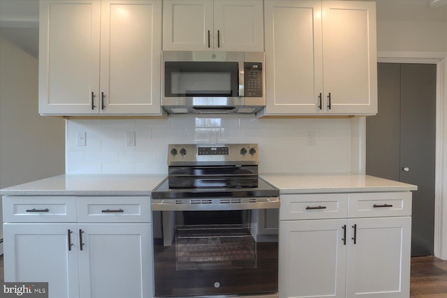 323 Plaza Dr, Palmyra, PA 17078 - kitchen with appliances with stainless steel finishes, decorative backsplash, dark wood-style flooring, and white cabinets