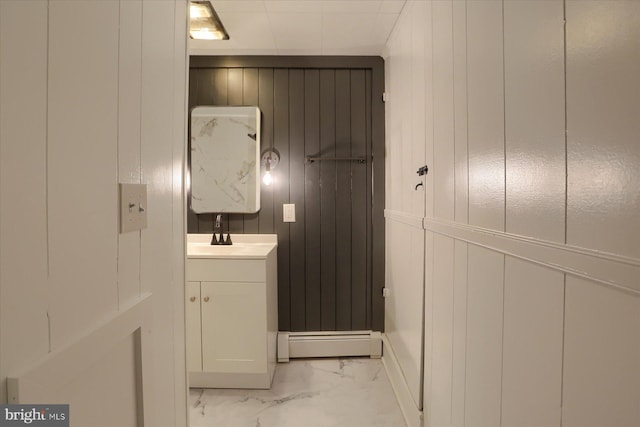 323 Plaza Dr, Palmyra, PA 17078 - bathroom with a baseboard radiator, marble finish floors, vanity, a decorative wall, and wood walls