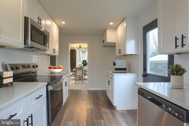 323 Plaza Dr, Palmyra, PA 17078 - kitchen with stainless steel appliances, dark wood finished floors, decorative backsplash, white cabinets, and recessed lighting