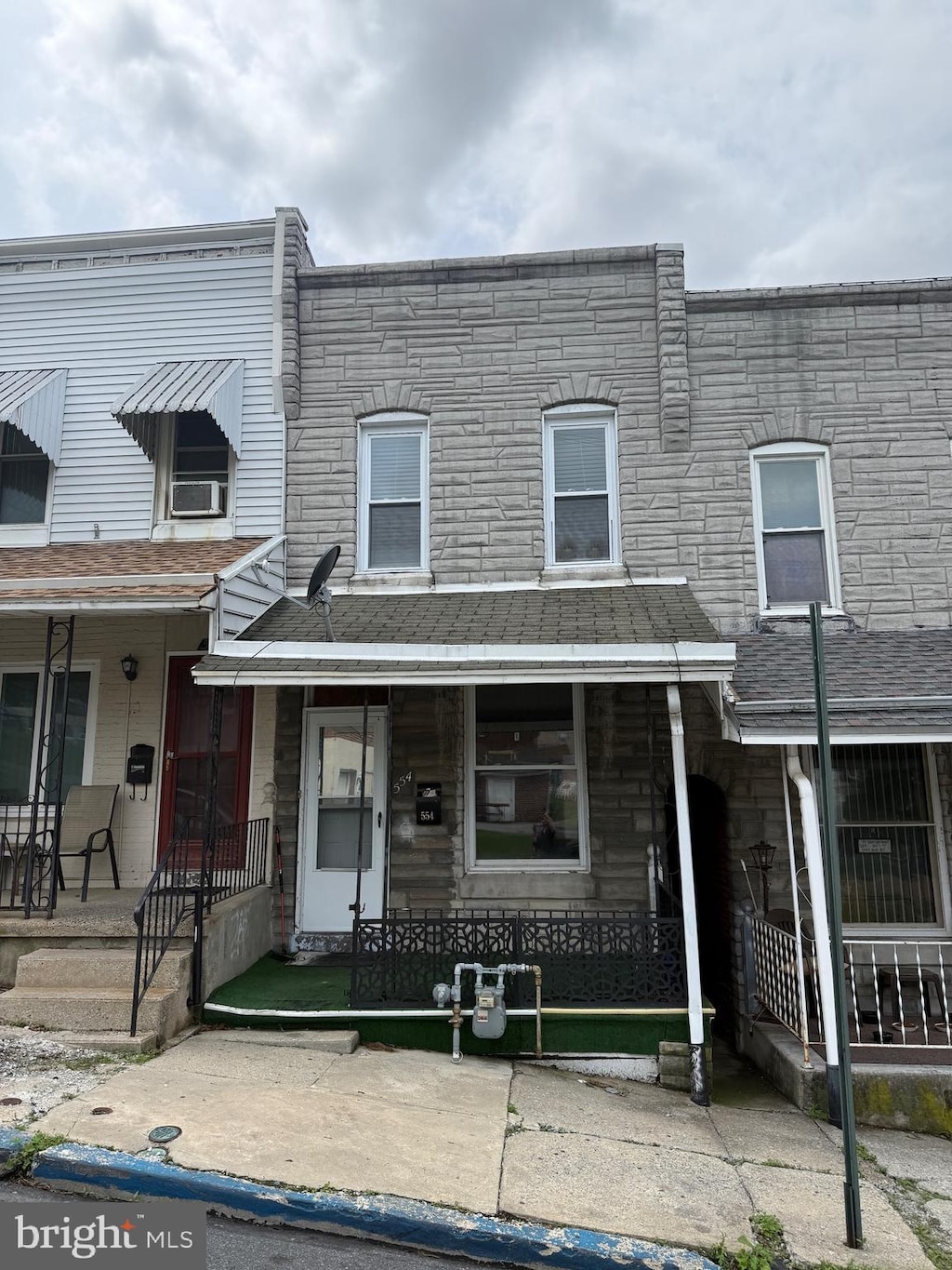 554 S 16 1/2 St, Reading, PA 19606 - view of property featuring a porch, stone siding, and cooling unit