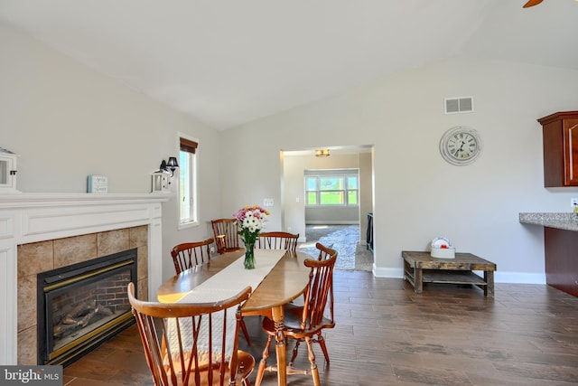 5221 Trumps Mill Rd, Baltimore, MD 21206 - dining room featuring vaulted ceiling, a tiled fireplace, and dark wood-style flooring
