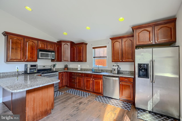 5221 Trumps Mill Rd, Baltimore, MD 21206 - kitchen with stainless steel appliances, a peninsula, light stone countertops, wood finished floors, and vaulted ceiling