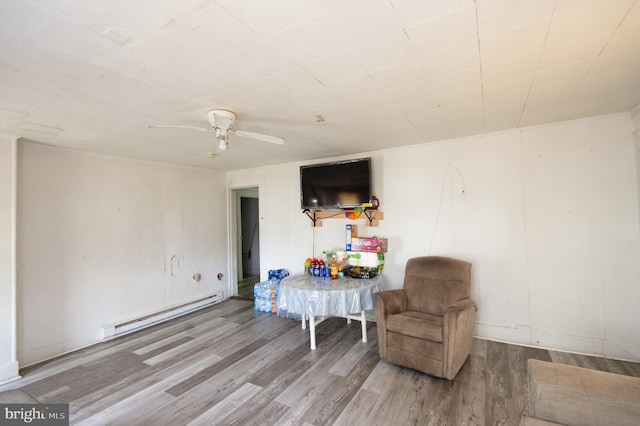 113 Washington St, Cambridge, MD 21613 - living area featuring a baseboard radiator, wood finished floors, a ceiling fan, and baseboards