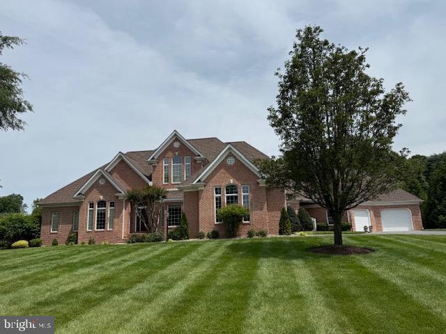 9 Chadwick Dr, Dover, DE 19901 - view of front facade with brick siding, a front yard, and a garage