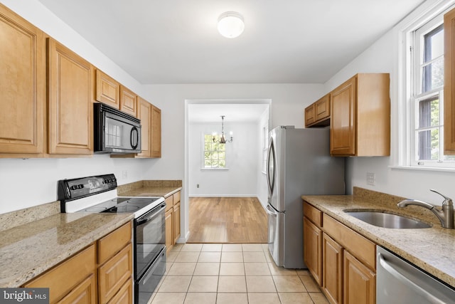 534 Hillcrest Ave, Glenside, PA 19038 - kitchen with black appliances, a sink, light stone countertops, and a chandelier