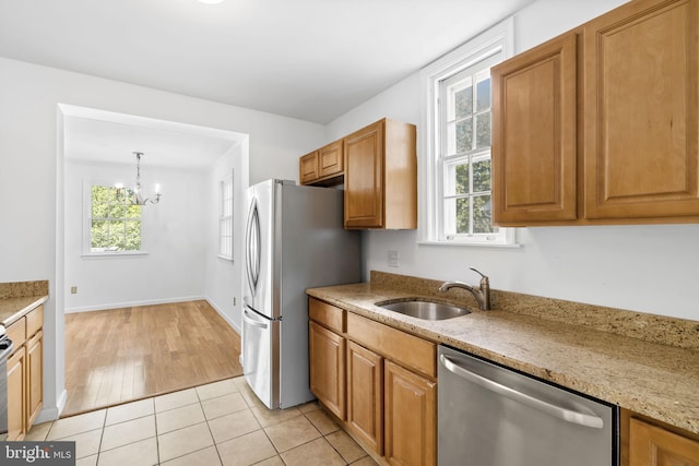 534 Hillcrest Ave, Glenside, PA 19038 - kitchen with stainless steel appliances, a sink, light stone counters, a chandelier, and brown cabinets