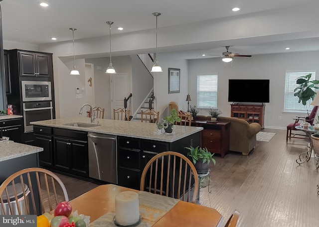 8716 Windon Ct, Waldorf, MD 20603 - kitchen with stainless steel appliances, a sink, ceiling fan, a center island with sink, and dark cabinetry