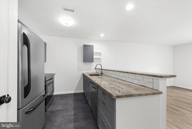 207 Fairfield Ct Unit 207, West Chester, PA 19382 - kitchen with stainless steel appliances, a sink, a peninsula, gray cabinets, and light stone counters