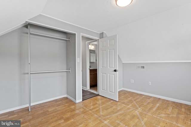 95 Twin Oak Dr, Levittown, PA 19056 - unfurnished bedroom with light wood finished floors, a closet, vaulted ceiling, and baseboards