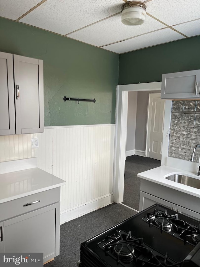 3 E Mantua Ave, Wenonah, NJ 08090 - kitchen with a sink, gray cabinetry, black range with gas stovetop, a wainscoted wall, and a drop ceiling