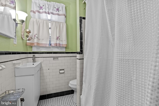 2824 Ashland Ave, Baltimore, MD 21205 - full bath featuring tile walls, toilet, vanity, a wainscoted wall, and tile patterned floors