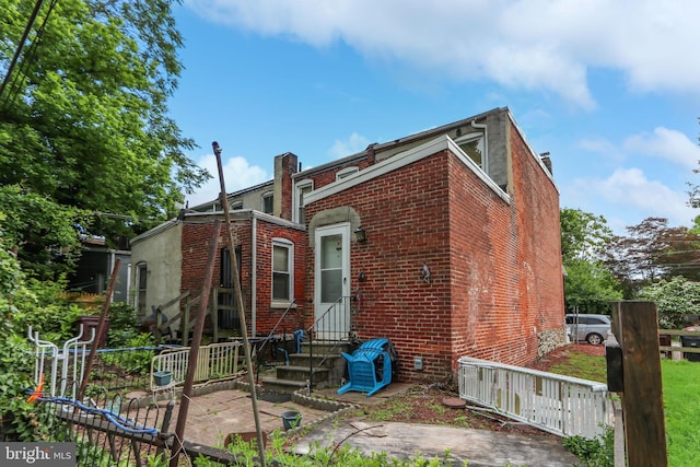 2227 Carter St, Wilmington, DE 19802 - back of property featuring a chimney, brick siding, and entry steps