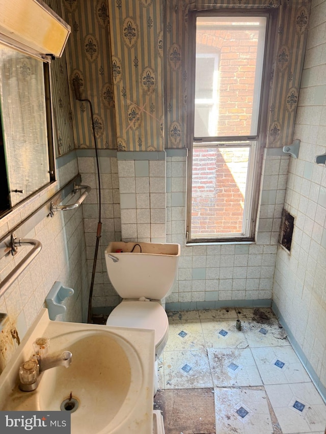 1007 Appleton St, Baltimore, MD 21217 - half bath with a sink, toilet, tile walls, and wallpapered walls