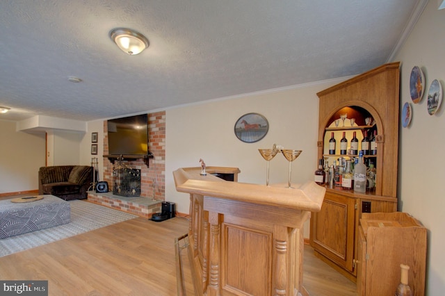 3405 Sundown Farms Way, Olney, MD 20832 - indoor dry bar featuring a textured ceiling, light wood finished floors, a brick fireplace, ornamental molding, and baseboards