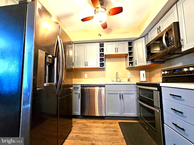 5200 Hilltop Dr Unit Bb-17, Brookhaven, PA 19015 - kitchen with appliances with stainless steel finishes, ceiling fan, open shelves, light wood-style flooring, and light countertops