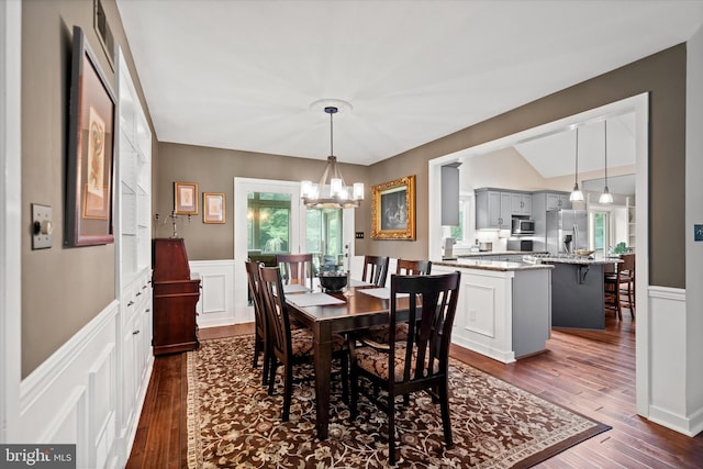 114 W Pembrey Dr, Wilmington, DE 19803 - dining space featuring wainscoting, a chandelier, dark wood finished floors, a decorative wall, and vaulted ceiling