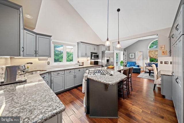 114 W Pembrey Dr, Wilmington, DE 19803 - kitchen with appliances with stainless steel finishes, gray cabinetry, open floor plan, a kitchen breakfast bar, and light stone counters