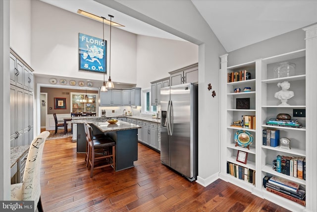 114 W Pembrey Dr, Wilmington, DE 19803 - kitchen featuring stainless steel fridge with ice dispenser, gray cabinets, a center island, high vaulted ceiling, and stone countertops