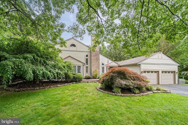 114 W Pembrey Dr, Wilmington, DE 19803 - view of front facade with an attached garage, asphalt driveway, a chimney, and a front lawn