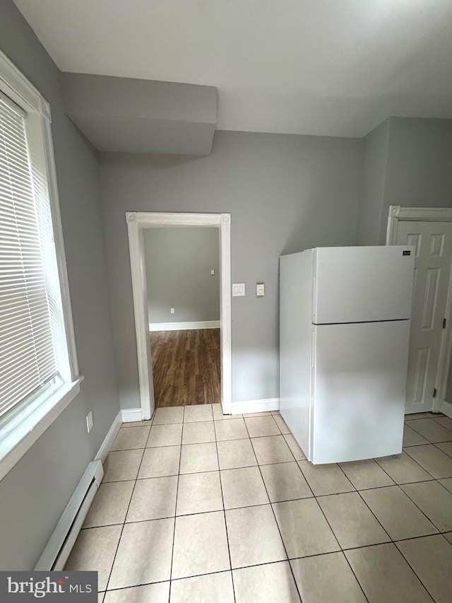 4549 N Mole St, Philadelphia, PA 19140 - kitchen featuring freestanding refrigerator, a baseboard radiator, light tile patterned floors, and baseboards