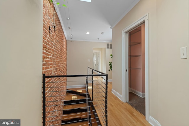 3006 Dillon St, Baltimore, MD 21224 - stairway with wood finished floors, crown molding, baseboards, recessed lighting, and brick wall