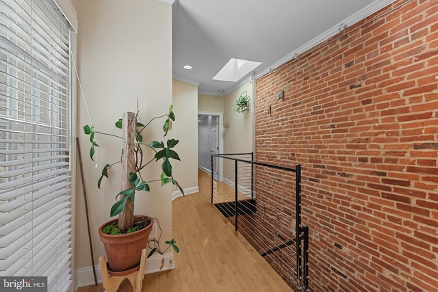 3006 Dillon St, Baltimore, MD 21224 - hallway with a skylight, baseboards, brick wall, hardwood / wood-style flooring, and crown molding