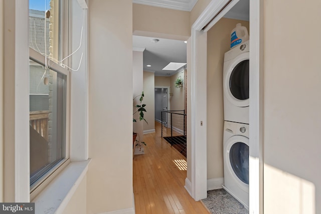 3006 Dillon St, Baltimore, MD 21224 - laundry room with stacked washing machine and dryer, ornamental molding, baseboards, and wood-type flooring