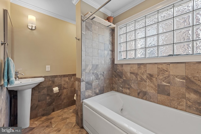 3006 Dillon St, Baltimore, MD 21224 - bathroom featuring tile walls, a tub with jets, ornamental molding, a wainscoted wall, and a sink