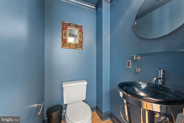 3006 Dillon St, Baltimore, MD 21224 - bathroom featuring toilet, a sink, baseboards, and wood finished floors