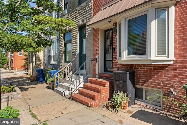 3006 Dillon St, Baltimore, MD 21224 - property entrance with brick siding, a standing seam roof, metal roof, and a surveillance system