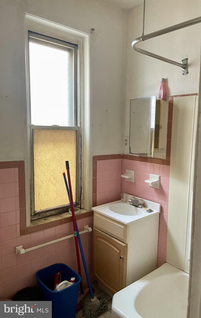 542 W Tioga St, Philadelphia, PA 19140 - bathroom with tile walls, vanity, and a wainscoted wall