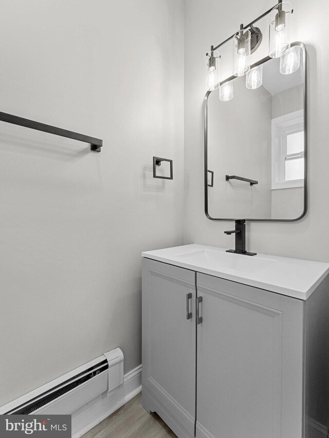 2223 W Indiana Ave, Philadelphia, PA 19132 - bathroom featuring baseboard heating, vanity, wood finished floors, and baseboards