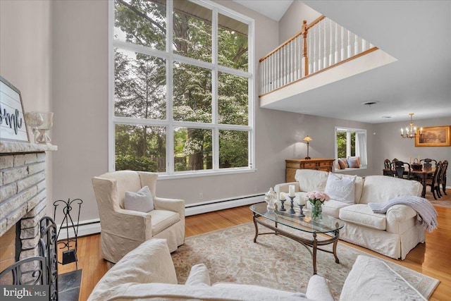 1 Birchall Dr, Haddonfield, NJ 08033 - living room featuring baseboard heating, a chandelier, a fireplace, wood finished floors, and a towering ceiling
