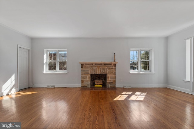 6901 Park Heights Ave, Baltimore, MD 21215 - unfurnished living room featuring wood finished floors, a stone fireplace, baseboards, and ornamental molding
