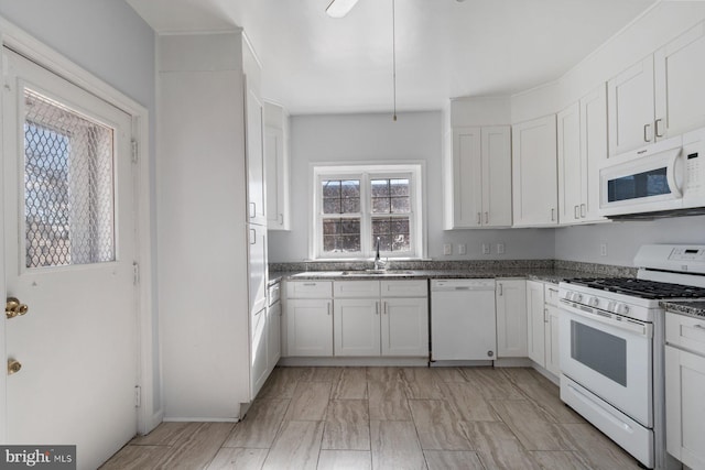 6901 Park Heights Ave, Baltimore, MD 21215 - kitchen with white appliances, a sink, white cabinets, and dark stone counters
