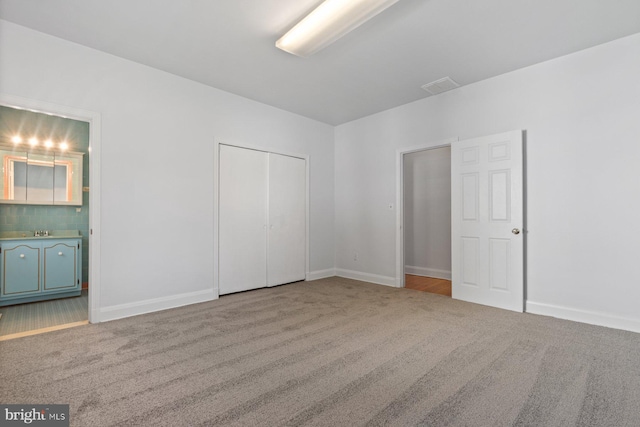 6901 Park Heights Ave, Baltimore, MD 21215 - unfurnished bedroom with carpet floors, ensuite bathroom, baseboards, and a closet