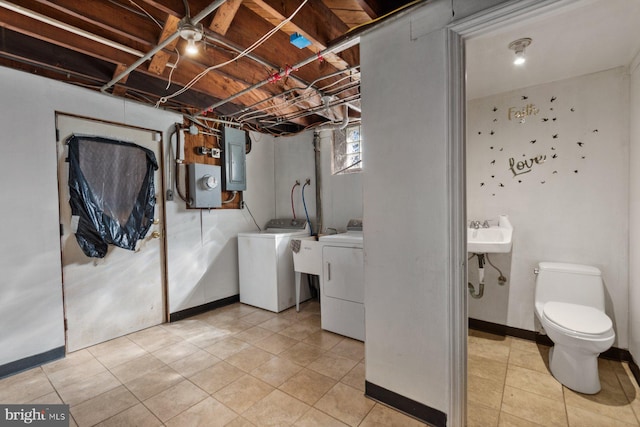 6901 Park Heights Ave, Baltimore, MD 21215 - laundry area featuring washer and dryer, light tile patterned flooring, and baseboards