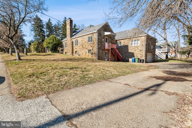 6901 Park Heights Ave, Baltimore, MD 21215 - view of side of property with stairs, an attached garage, asphalt driveway, a yard, and a chimney