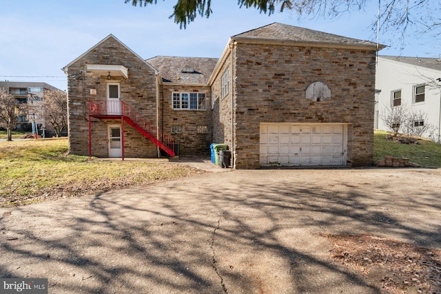 6901 Park Heights Ave, Baltimore, MD 21215 - view of front facade with driveway, an attached garage, stone siding, and stairway