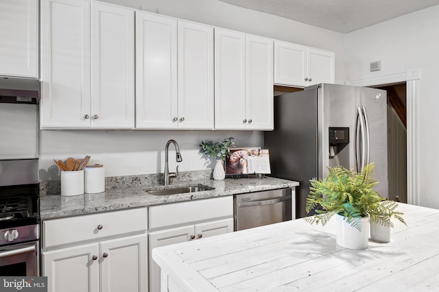 511 S E Ave, Baltimore, MD 21224 - kitchen featuring stainless steel appliances, a sink, white cabinets, and light stone counters