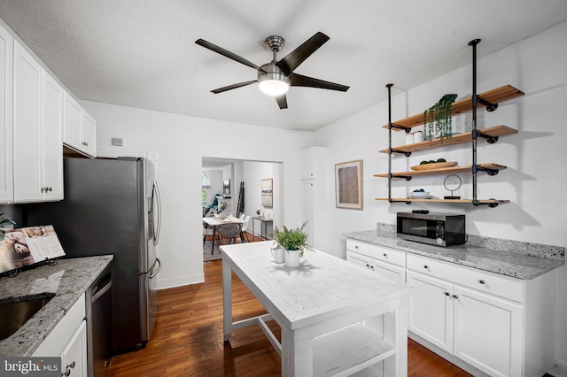 511 S E Ave, Baltimore, MD 21224 - kitchen featuring stainless steel appliances, a ceiling fan, dark wood-style flooring, white cabinetry, and light stone counters