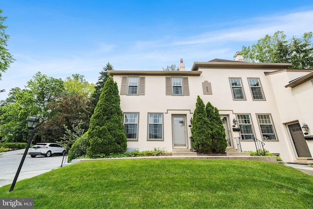 229 Bloomingdale Ave Unit 1, Wayne, PA 19087 - view of property with stucco siding, a front yard, and a chimney