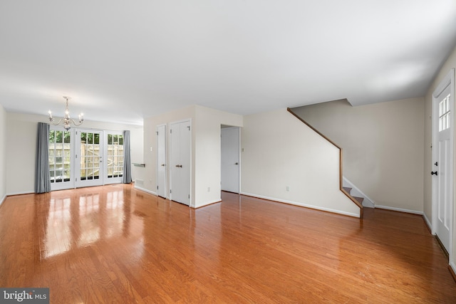 229 Bloomingdale Ave Unit 1, Wayne, PA 19087 - unfurnished living room with a chandelier, light wood-style flooring, baseboards, and stairway