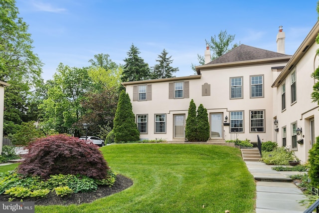 229 Bloomingdale Ave Unit 1, Wayne, PA 19087 - view of front of home featuring a front lawn, stucco siding, entry steps, and a chimney