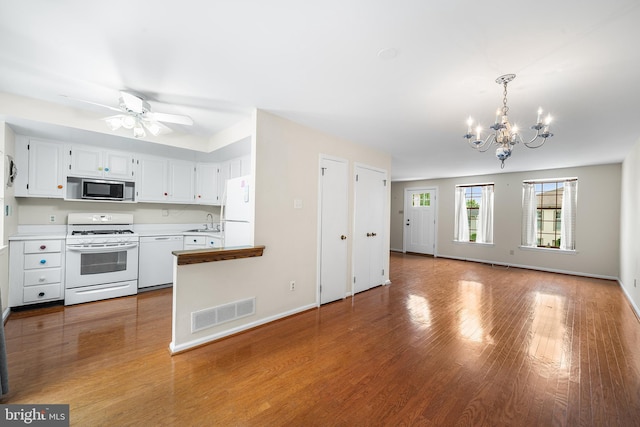 229 Bloomingdale Ave Unit 1, Wayne, PA 19087 - kitchen featuring white appliances, a chandelier, open floor plan, a sink, and wood finished floors
