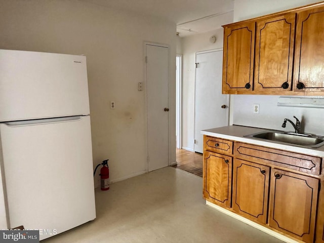 11 Cardinal St Unit D, Manchester, NJ 08759 - kitchen with freestanding refrigerator, a sink, brown cabinetry, and light countertops