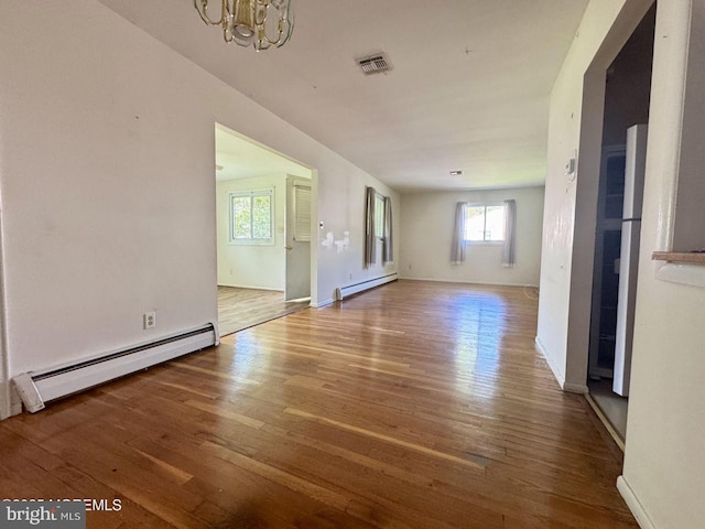 11 Cardinal St Unit D, Manchester, NJ 08759 - unfurnished living room featuring a baseboard heating unit, a chandelier, and wood finished floors