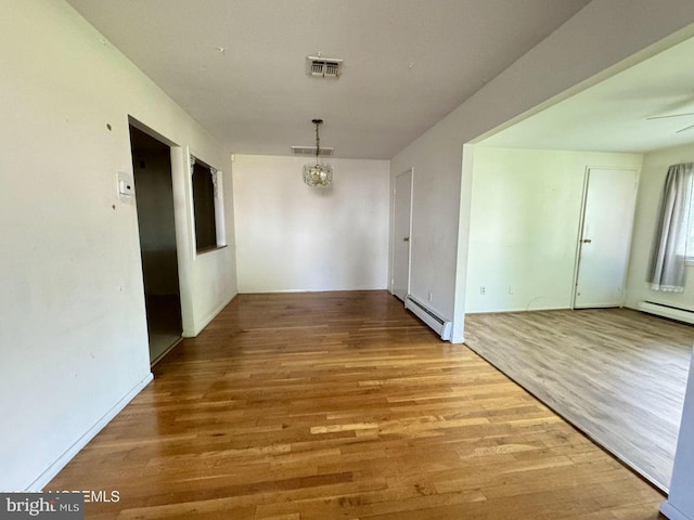 11 Cardinal St Unit D, Manchester, NJ 08759 - unfurnished dining area with baseboard heating, wood finished floors, a chandelier, a baseboard radiator, and ceiling fan